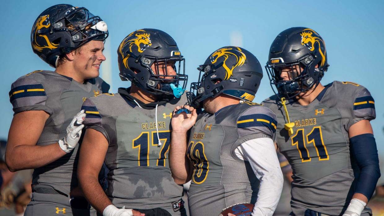 Clarke defensive players grouped on the sideline